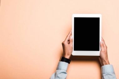 pembe üzerinde boş ekran ile dijital tablet tutarak elinde akıllı saat ile kadın kırpılmış görünümü 