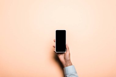 pembe üzerinde boş ekran ile akıllı telefon tutan kadın kırpılmış görünümü 