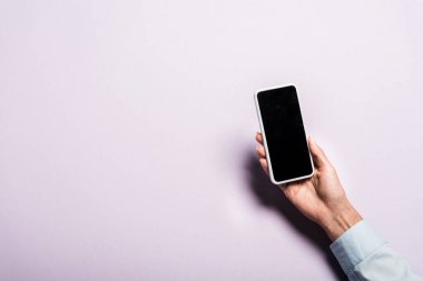mor boş ekran ile akıllı telefon tutan kadın kırpılmış görünümü