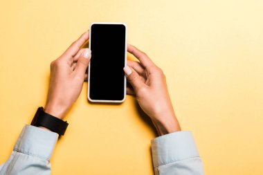 turuncu boş ekran ile akıllı telefon tutan kadın kırpılmış görünümü