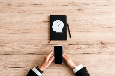 top view of woman holding smartphone with blank screen near notebook and paper human head with question mark  clipart