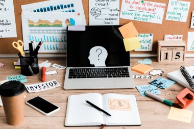 laptop and smartphone with blank screens on table near notice board with letters and sticky notes  clipart