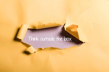 tattered paper with think outside box lettering and rolled edges on orange clipart
