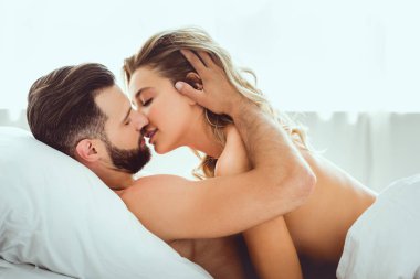 yatakta yatarken güzel kız arkadaşı öpüşme yakışıklı genç adam