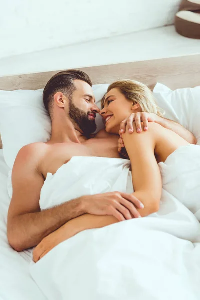 Happy Young Couple Embracing Looking Each Other While Lying Bed — Stock Photo, Image