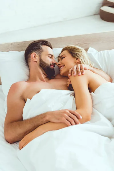 Feliz Joven Pareja Abrazándose Mirándose Mientras Están Acostados Cama — Foto de Stock