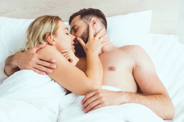 Happy Young Couple Hugging Kissing Closed Eyes While Lying Bed — Stock Photo, Image