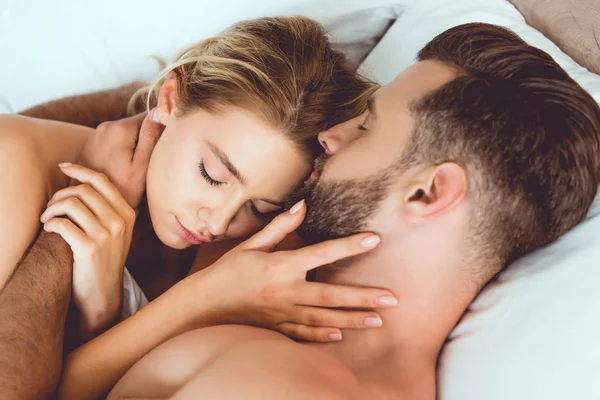 Feliz Jovem Casal Abraçando Com Olhos Fechados Enquanto Deitado Cama — Fotografia de Stock