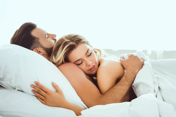 Feliz Jovem Casal Abraçando Com Olhos Fechados Enquanto Deitado Cama — Fotografia de Stock