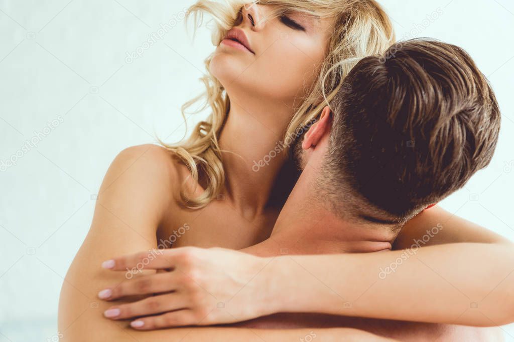 back view of man hugging and kissing beautiful, sexy girlfriend