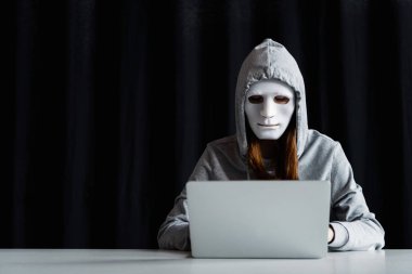 siyah dizüstü bilgisayar klavyesinde yazarak maske anonim internet troll