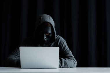 siyah dizüstü bilgisayar klavyesinde yazarak maske anonim internet troll