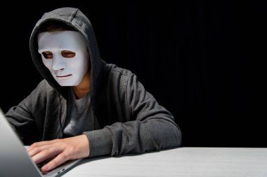 siyah izole dizüstü bilgisayar klavyesinde yazarak maske anonim internet troll