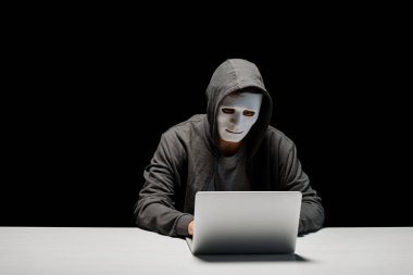 siyah izole dizüstü bilgisayar klavyesinde yazarak maske anonim internet troll