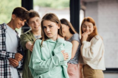 panoramic shot of group of teenagers bullying girl clipart