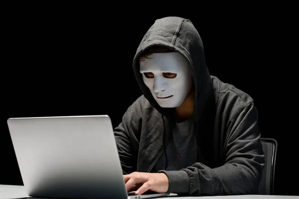 匿名互联网巨魔在面具打字笔记本电脑键盘上隔离黑色 — 图库照片