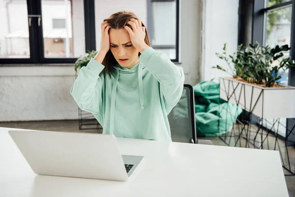 Aufgebrachtes Mädchen Kapuzenpulli Das Tisch Sitzt Und Den Kopf Berührt — Stockfoto