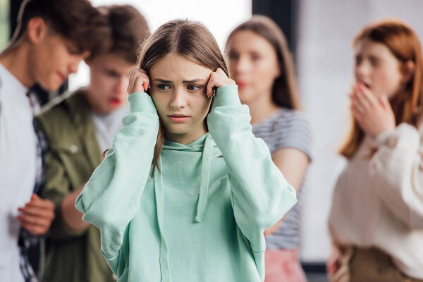 panoramic shot of group of teenagers bullying girl