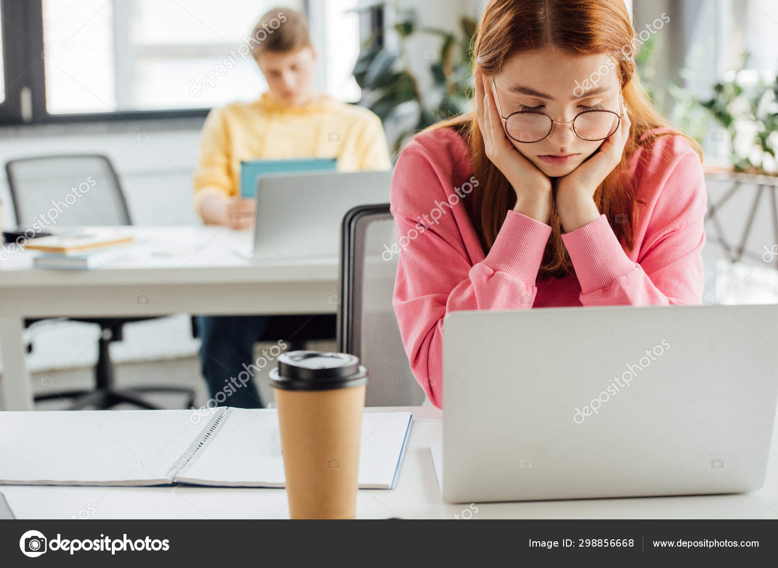 Pensive Schoolchildren Sitting Desks Using Laptops Stock Photo