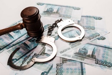 wooden gavel near handcuffs on russian money  clipart