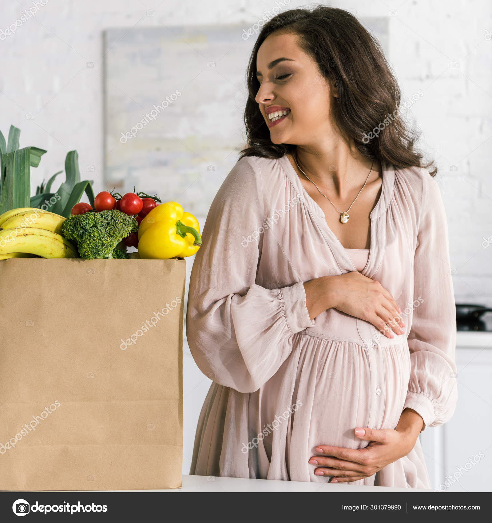 Cheerful Pregnant Woman Looking Paper Bag Groceries While Touching
