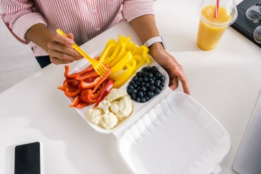 gıda kabında sebze yakınında plastik çatal tutan kadın üst görünümü 