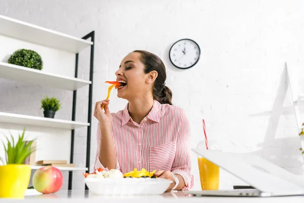 Enfoque Selectivo Chica Atractiva Comer Pimentón Cerca Computadora Portátil —  Fotos de Stock