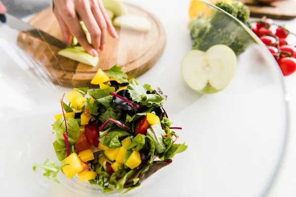 Enfoque Selectivo Cuenco Vidrio Con Ensalada Cerca Mujer Corte Manzana —  Fotos de Stock