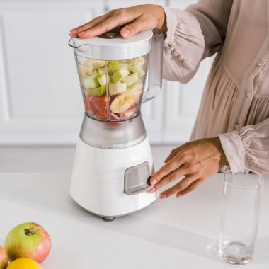 meyve ile blender üzerinde düğmeye dokunarak hamile kadın kırpılmış görünümü 