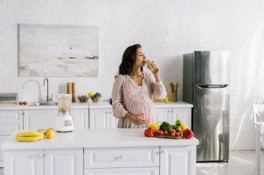 lezzetli gıda ile masa yakınında smoothie içme hamile kadın 