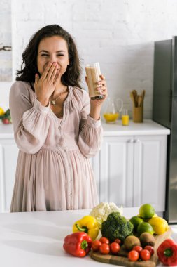 lezzetli smoothie ve kaplama yüzü ile cam tutan neşeli hamile kadın 