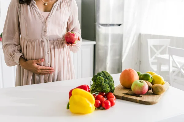 Vista Recortada Mujer Embarazada Tocando Vientre Sosteniendo Manzana — Foto de Stock