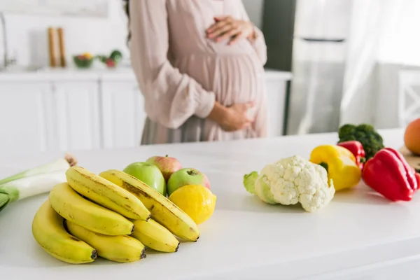 Vista Recortada Mujer Embarazada Pie Cerca Frutas Mesa — Foto de Stock