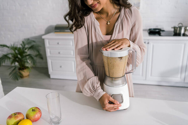 cropped view of cheerful pregnant woman preparing smoothie 