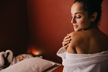 spa salonunda bornoz kapalı gözlü çekici kadın