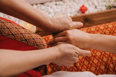 spa salonunda kadına el masajı yapan masör kırpılmış görünümü 