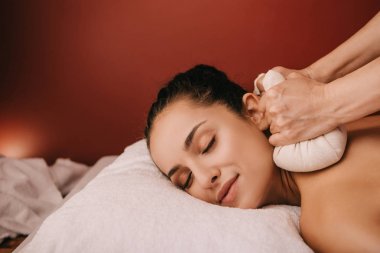 spa kadın bitkisel topları ile geri masaj yapıyor masör kırpılmış görünümü