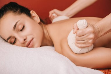 spa kadın bitkisel topları ile geri masaj yapıyor masör kırpılmış görünümü