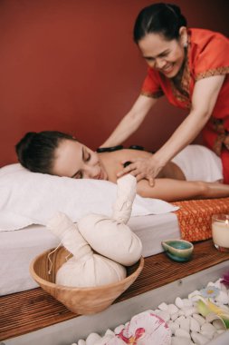 bitkisel topları ve asya masör sıcak taş masajı yapıyor seçici odak 