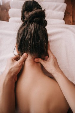 cropped view of masseur doing neck massage to woman in spa salon  clipart
