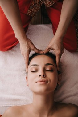 spa salonunda kadına yüz masajı yapan masör kırpılmış görünümü 