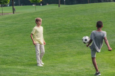 çim üzerinde futbol oynayan sevimli çok kültürlü çocuklar 