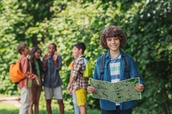 Enfoque Selectivo Niño Feliz Rizado Sosteniendo Mapa Cerca Amigos — Foto de Stock