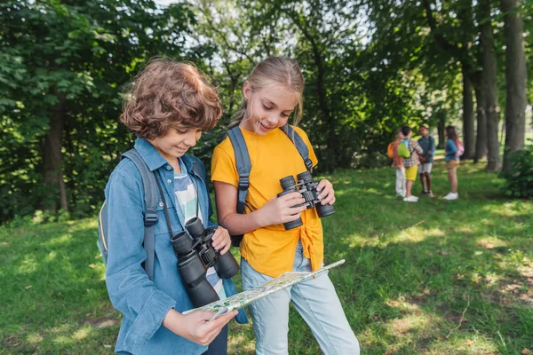 选择焦点的快乐的孩子用双筒望远镜看地图 — 图库照片