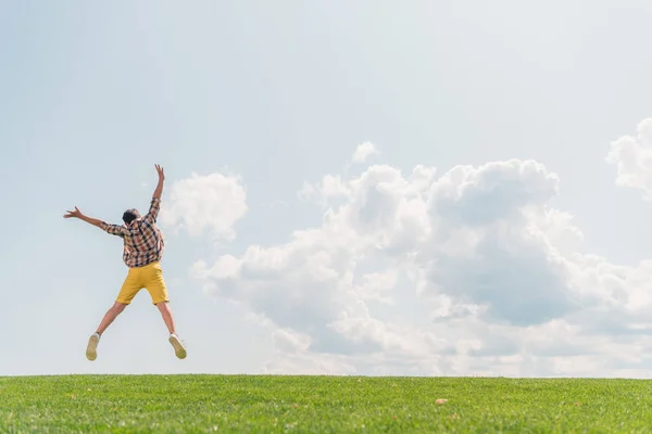 Achteraanzicht Van Jongen Springen Gebaren Tegen Blauwe Hemel — Stockfoto