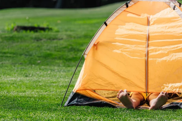 Vista Cortada Menino Com Pés Descalços Deitado Acampamento Amarelo — Fotografia de Stock