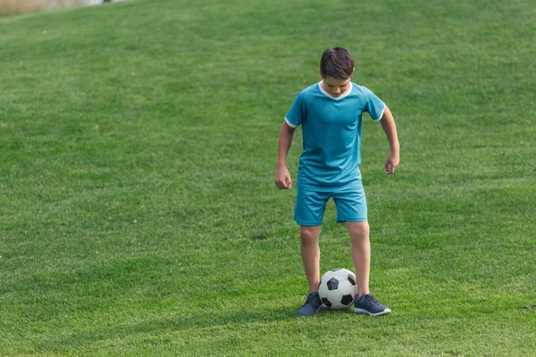 Παιδί Αθλητικά Ρούχα Στέκεται Πράσινο Γρασίδι Ποδόσφαιρο — Φωτογραφία Αρχείου