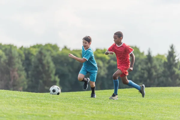 Podekscytowany Wielokulturowe Dzieci Grających Piłkę Nożną Trawie — Zdjęcie stockowe