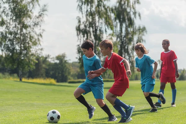 Quattro Bambini Multiculturali Che Giocano Calcio Sull Erba — Foto Stock