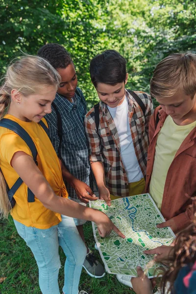 Garoto Feliz Apontando Com Dedo Mapa Perto Amigos Multiculturais — Fotografia de Stock